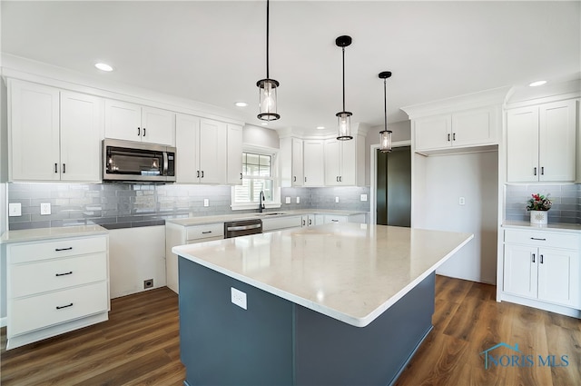 kitchen featuring a kitchen island, dark hardwood / wood-style flooring, white cabinetry, and appliances with stainless steel finishes