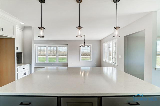 kitchen featuring light stone countertops, decorative light fixtures, and a kitchen island