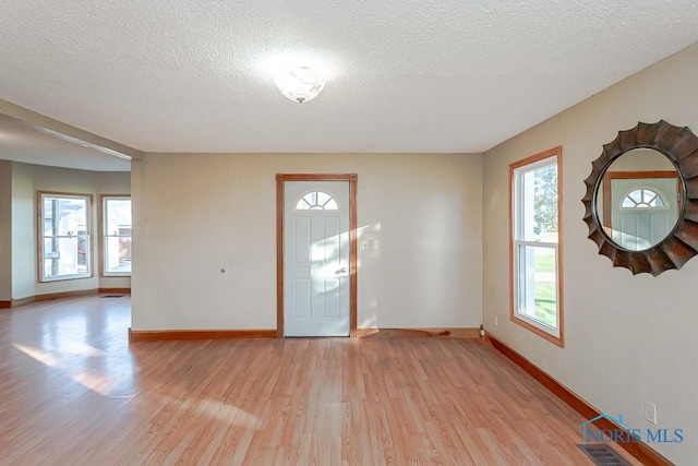 interior space with light wood-type flooring and a textured ceiling