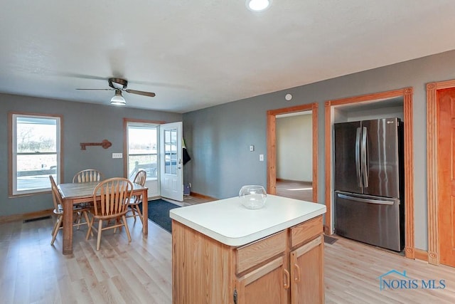 kitchen with a center island, light brown cabinets, light hardwood / wood-style flooring, ceiling fan, and stainless steel refrigerator