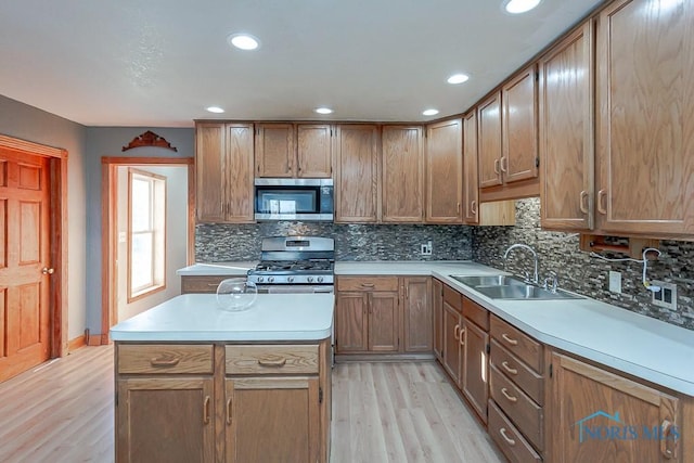 kitchen with sink, light wood-type flooring, stainless steel appliances, and tasteful backsplash