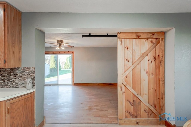 interior space featuring ceiling fan and a barn door