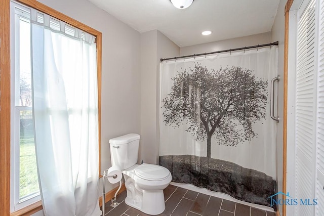 bathroom with a shower with curtain, hardwood / wood-style flooring, toilet, and a wealth of natural light