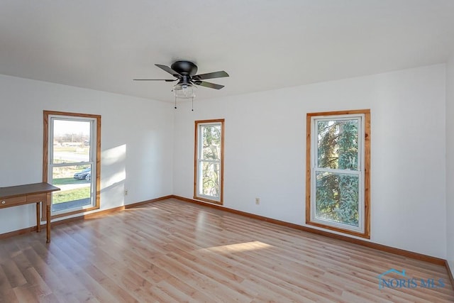 spare room with ceiling fan, a healthy amount of sunlight, and light hardwood / wood-style floors