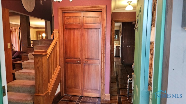 interior space featuring dark tile patterned flooring and crown molding