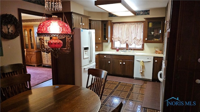 kitchen featuring decorative light fixtures, white appliances, sink, and dark brown cabinets