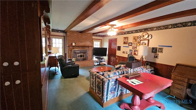 living room with beamed ceiling, ceiling fan, wood walls, and carpet