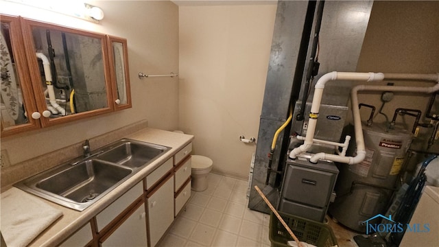 bathroom with toilet, vanity, and gas water heater