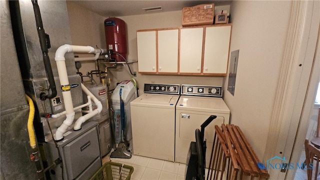 laundry area featuring washing machine and clothes dryer, cabinets, and electric panel