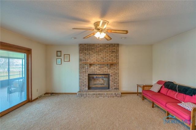 living room featuring a textured ceiling, ceiling fan, a fireplace, and light carpet