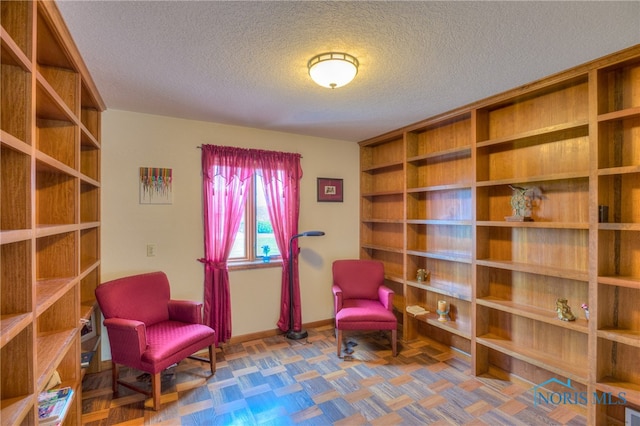 living area featuring a textured ceiling and parquet flooring