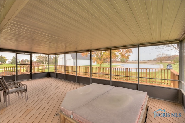 sunroom / solarium with a water view, vaulted ceiling, a wealth of natural light, and wood ceiling