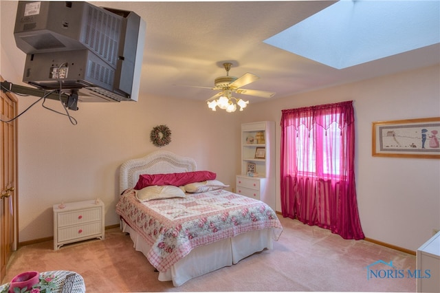 bedroom featuring ceiling fan, light carpet, and a skylight