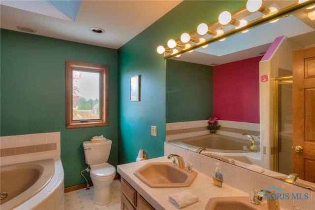 full bathroom with a skylight, vanity, independent shower and bath, and toilet