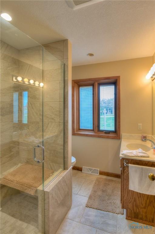 7733 Brown Rd, Curtice, OH 43412 - full bathroom with a shower stall, vanity, toilet, tile patterned floors, and baseboards