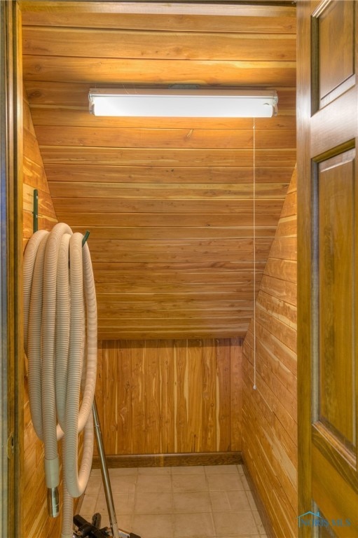 view of sauna / steam room with tile patterned flooring and wood walls