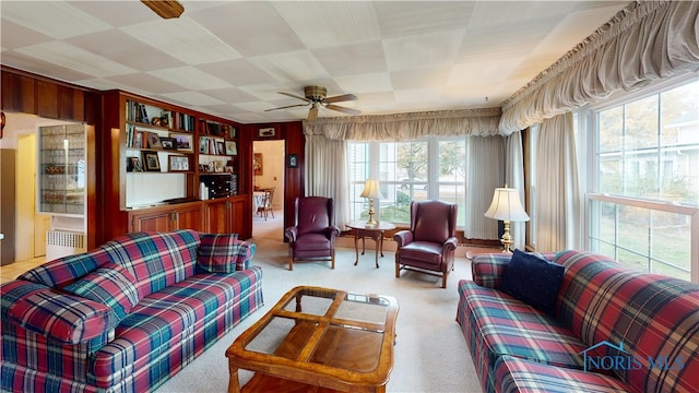 living room featuring radiator heating unit, light carpet, and ceiling fan