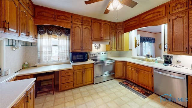 kitchen featuring stainless steel appliances, sink, and ceiling fan