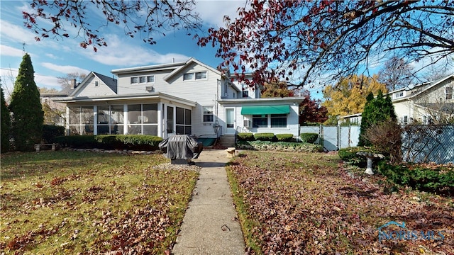 view of front facade with a sunroom and a front yard