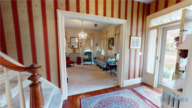 entryway with hardwood / wood-style flooring and a notable chandelier