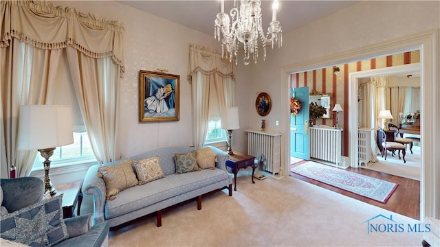 sitting room with a notable chandelier and hardwood / wood-style flooring