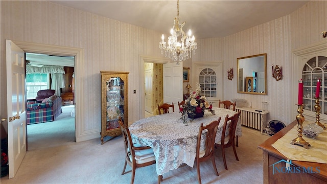 dining room with light carpet and a notable chandelier