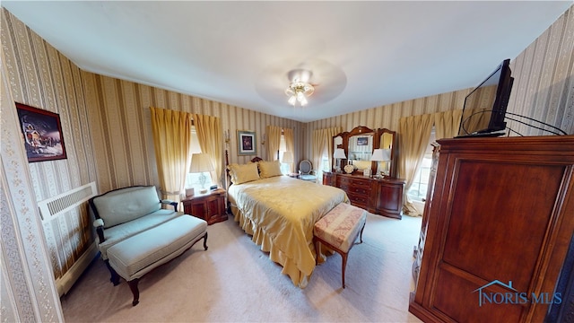 carpeted bedroom featuring multiple windows and ceiling fan