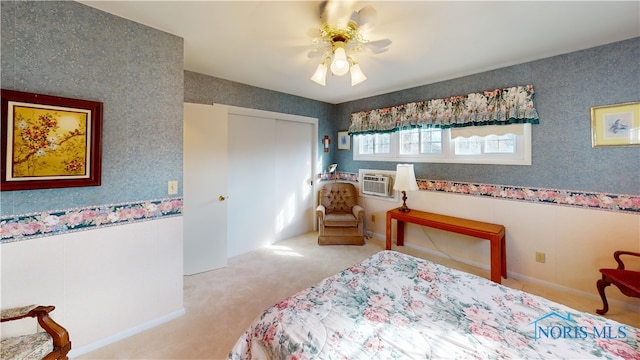 bedroom featuring an AC wall unit, a closet, light colored carpet, and ceiling fan