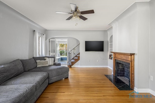 living room with hardwood / wood-style floors, ceiling fan, and built in features