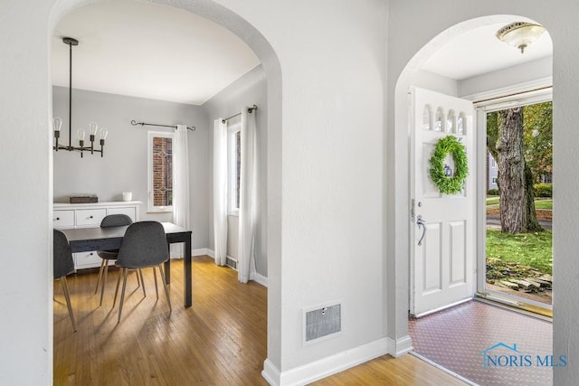 entrance foyer featuring hardwood / wood-style flooring and a chandelier