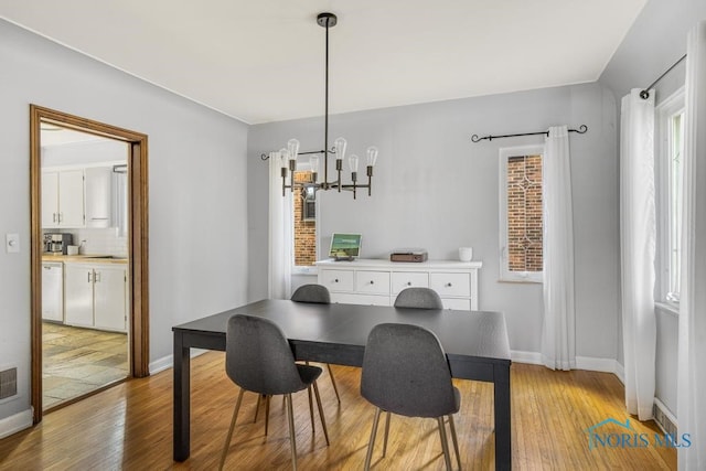 dining room featuring light hardwood / wood-style flooring and a notable chandelier