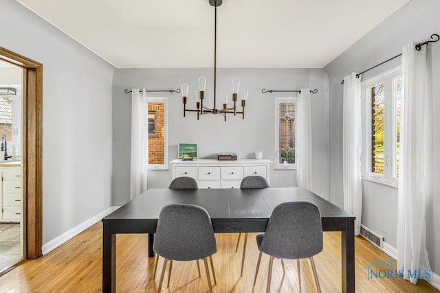 dining room featuring a chandelier, light hardwood / wood-style floors, and a healthy amount of sunlight