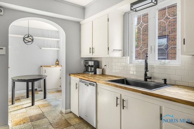 kitchen featuring white cabinetry, butcher block counters, sink, and backsplash