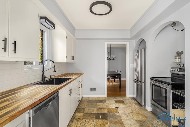 kitchen with appliances with stainless steel finishes, sink, and white cabinets