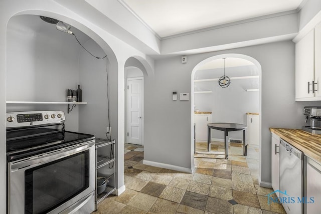 kitchen featuring butcher block counters, white cabinets, appliances with stainless steel finishes, and crown molding