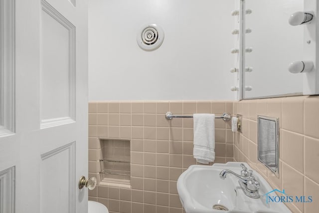 bathroom featuring tile walls and sink