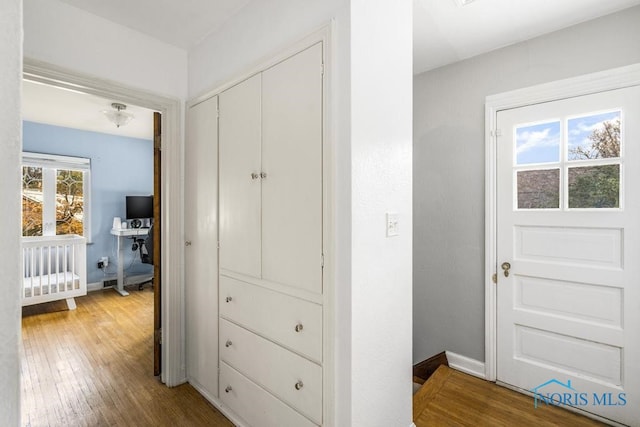 hallway with hardwood / wood-style flooring and a healthy amount of sunlight