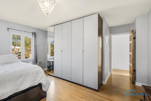 bedroom featuring a notable chandelier and light hardwood / wood-style floors