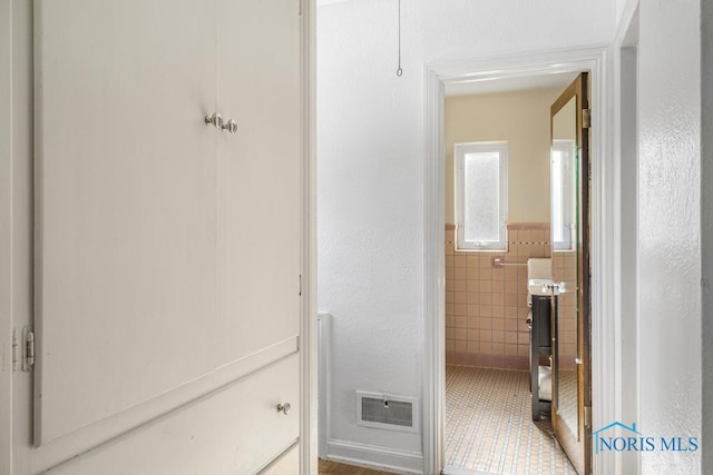 bathroom with tile walls and tile patterned flooring