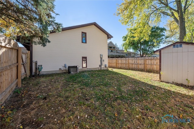 back of house with a yard and a shed