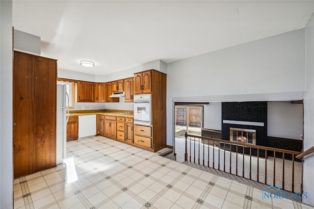 kitchen with white appliances and a fireplace