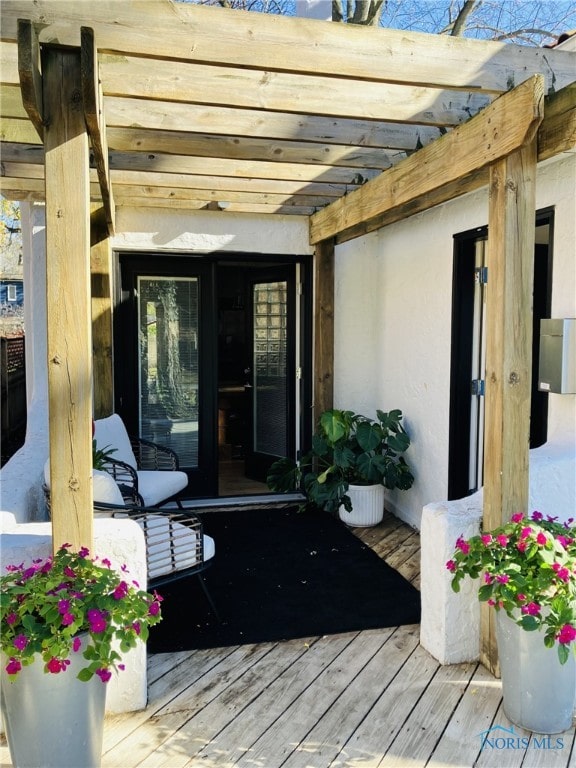 doorway to property with a pergola and a deck