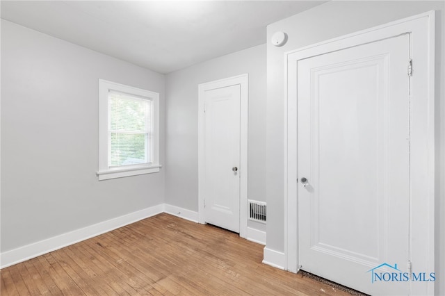 unfurnished bedroom featuring a closet and light wood-type flooring