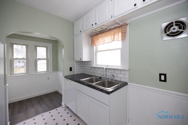 kitchen featuring sink, tasteful backsplash, white dishwasher, white cabinets, and light wood-type flooring