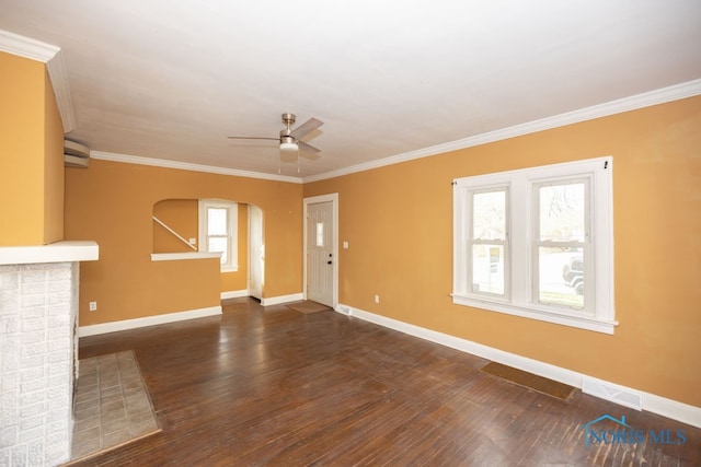 unfurnished living room with dark hardwood / wood-style flooring, ornamental molding, a wall mounted AC, ceiling fan, and a fireplace