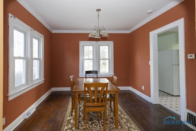 dining space with ornamental molding, dark hardwood / wood-style floors, and a notable chandelier