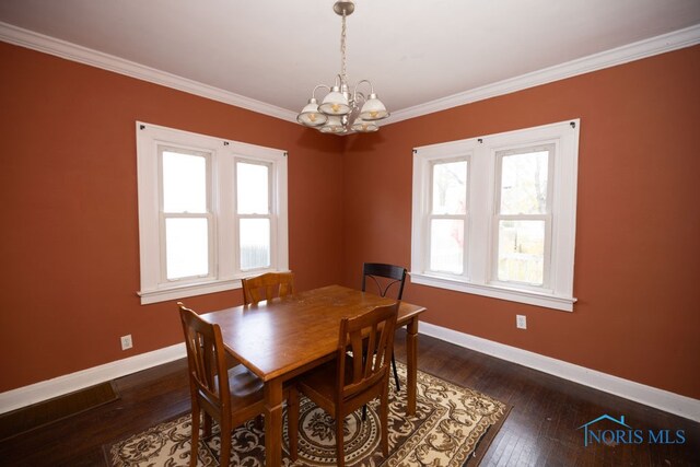 dining area featuring crown molding, a chandelier, and dark hardwood / wood-style floors