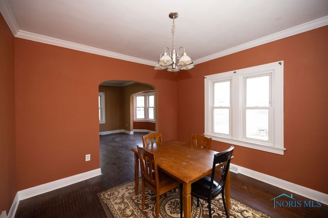 dining area with a notable chandelier, dark hardwood / wood-style flooring, and ornamental molding