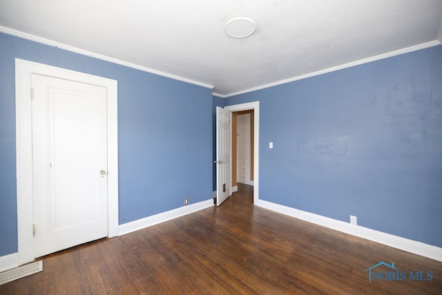 spare room featuring crown molding and dark hardwood / wood-style flooring