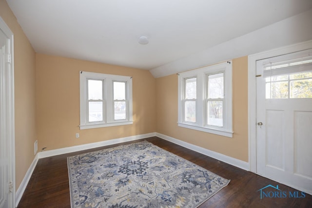 foyer with dark wood-type flooring and vaulted ceiling